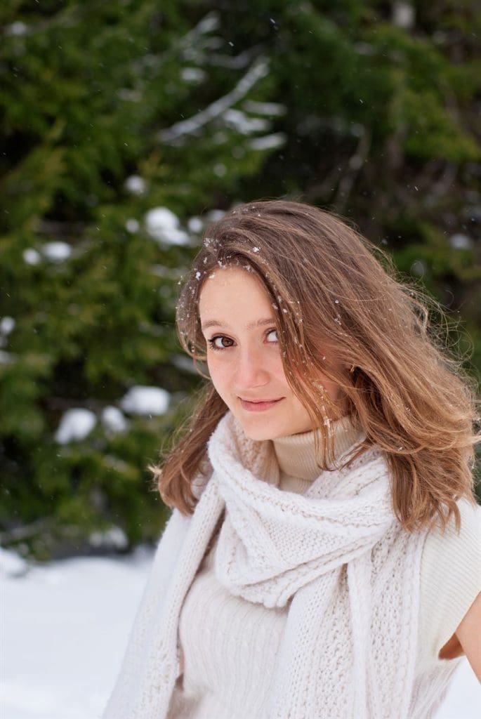 Smiling Caucasian Young Woman posing in Snowy Winter