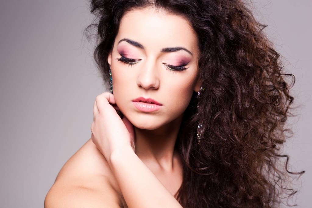 cute girl with curly hair wearing make-up - studio shot