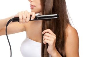 Young woman iwth a hair straightener